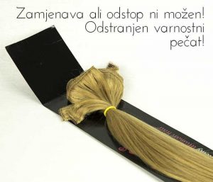 Snop svetlo rjavih lasnih podaljškov z rumenim trakom na črni podlagi in napisom 'Zamenjava ni možna'.“